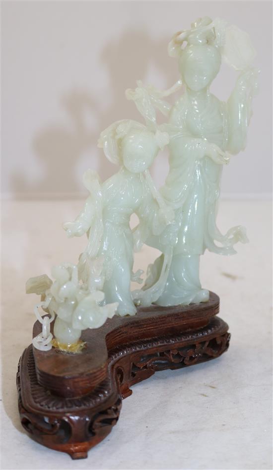 A Chinese pale celadon jade group of a lady and a girl with flowing robes, a basket beside them, 20th century, total height 19cm